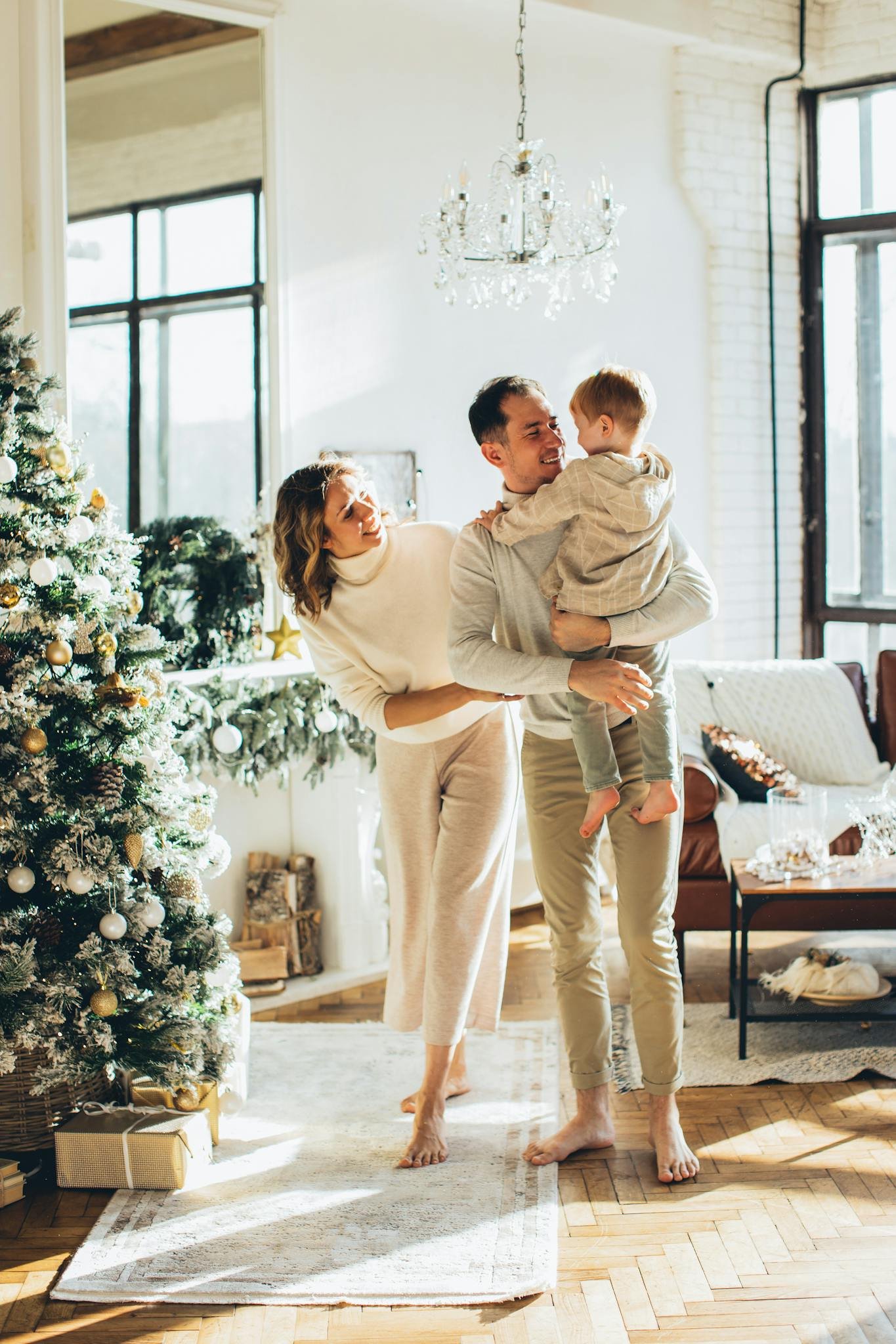 Family enjoying quality time by a Christmas tree in a cozy living room.